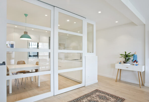 Sistema Essential Timber de puertas correderas con guías y ruedas para puertas de hasta 90 kg, ideal para interiores modernos.